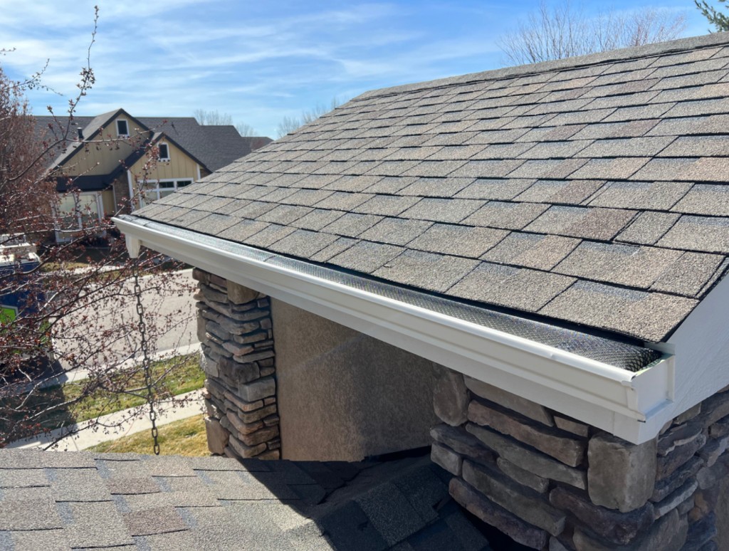 Close-up of mesh gutter guards on a South Florida home with stone veneer