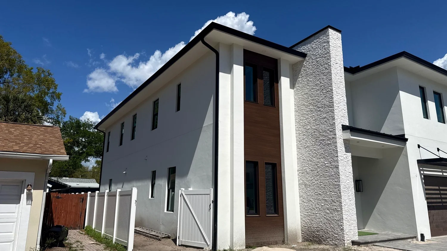 Charcoal gutters contrasting light siding on a contemporary Tampa residence